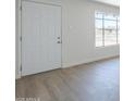 Bright entryway featuring a white door, brick accent wall, and luxury vinyl plank flooring at 4209 N 48Th Dr, Phoenix, AZ 85031