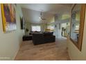 Bright, airy living room with wood-look floors, a ceiling fan and an open view to the kitchen at 6546 N 71St Ave, Glendale, AZ 85303