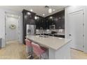 Bright and functional kitchen with stainless steel appliances, island, and dark wood cabinets at 6565 E Thomas Rd # 1128, Scottsdale, AZ 85251