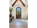 Elegant entryway features a wooden arched door, herringbone tile floors, and stylish decor at 7501 N Eucalyptus Dr, Paradise Valley, AZ 85253