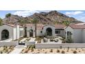 Stunning home exterior showcasing a tiled roof, desert landscaping, and picturesque mountain views at 7501 N Eucalyptus Dr, Paradise Valley, AZ 85253