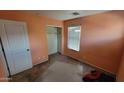 Bedroom with an empty closet, window with blinds and peach-colored walls at 8854 W Aster Dr, Peoria, AZ 85381