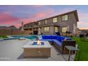 Outdoor oasis featuring a sparkling pool, cozy fire pit, and comfortable seating area for relaxation at 9342 W White Feather Ln, Peoria, AZ 85383