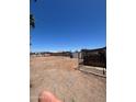 A large, empty lot backyard with fencing, desert landscape, and a clear blue sky at 9754 E Sunland Ave, Mesa, AZ 85208