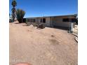 Exterior view of the side of a single-story mobile home on a gravel lot with carport at 9754 E Sunland Ave, Mesa, AZ 85208