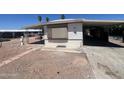 Exterior side view of single-story home with a carport on a gravel lot with desert landscaping at 9754 E Sunland Ave, Mesa, AZ 85208