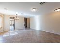 Spacious living room features tiled floors, neutral paint, and chandelier at 10517 W La Reata Ave, Avondale, AZ 85392