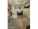 Cozy dining area featuring tile floors, a modern light fixture, and a dark table with chairs at 10610 S 48Th St # 1074, Phoenix, AZ 85044