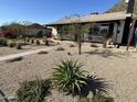 Well-maintained front yard with desert landscaping and mature trees at 112 W Vogel Ave, Phoenix, AZ 85021