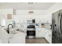 Bright, white kitchen features stainless steel appliances, modern finishes and an island with quartz countertop at 12209 W Washington St, Avondale, AZ 85323