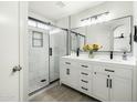 Modern primary bathroom with dual sinks, white cabinetry, and a glass-enclosed shower at 12209 W Washington St, Avondale, AZ 85323