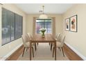 Well-lit dining room with neutral walls, wood floors and a view to the outside at 12450 W Hearn Rd, El Mirage, AZ 85335