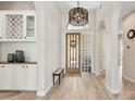 Bright foyer featuring a decorative door, tile floors, and stylish light fixture at 15037 N 114Th Way, Scottsdale, AZ 85255