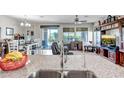 Open floor plan with kitchen island leading to a living room with large windows and neutral decor at 17520 W Fairview St, Goodyear, AZ 85338