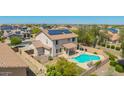 Aerial view of the home featuring a backyard pool, solar panels, covered patio, and fenced yard at 18419 W Maui Ln, Surprise, AZ 85388