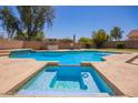 Backyard pool with a hot tub, ample seating space, and a well-kept desert landscape at 18419 W Maui Ln, Surprise, AZ 85388