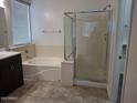 Bright bathroom featuring a soaking tub, shower, and tile flooring at 18447 W Verdin Rd, Goodyear, AZ 85338