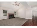 Bright living room featuring vaulted ceilings, cozy fireplace and a mix of carpet and wood flooring at 1918 S Shannon Dr, Tempe, AZ 85281