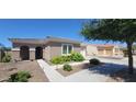 Charming single-story home featuring a tile roof, arched entryway, and vibrant yellow flowering bushes in the front yard at 20838 E Vía De Arboles --, Queen Creek, AZ 85142
