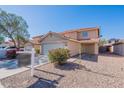 Inviting two-story home featuring a well-manicured front yard and a convenient two-car garage and desert landscaping at 22320 W Morning Glory St, Buckeye, AZ 85326
