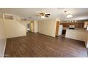 Open-concept living room and kitchen area with attractive wood-look floors and neutral paint at 22320 W Morning Glory St, Buckeye, AZ 85326