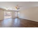 Spacious living room with wood-look flooring, sliding glass doors and multiple windows for natural light and a ceiling fan at 22320 W Morning Glory St, Buckeye, AZ 85326
