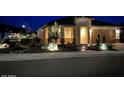 Single-story home featuring desert landscaping, accent rocks, and eye-catching outdoor lighting at 27021 W Kerry Ln, Buckeye, AZ 85396