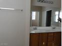 Bathroom with double sinks and a large mirror above a vanity with wood cabinets at 29797 W Mitchell Ave, Buckeye, AZ 85396