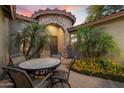 Inviting front courtyard with a stone archway, wrought-iron door, and outdoor dining area at 3350 S Holguin Way, Chandler, AZ 85248