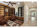 Cozy library featuring custom built-in bookshelves, decorative rug, and comfortable seating for reading and relaxation at 3350 S Holguin Way, Chandler, AZ 85248