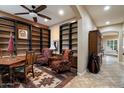 Cozy home office with bookshelves, patterned chairs, a decorative rug and wood accents at 3350 S Holguin Way, Chandler, AZ 85248