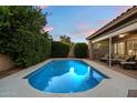 Relaxing backyard pool with covered patio and lush green landscaping and outdoor seating at 3350 S Holguin Way, Chandler, AZ 85248