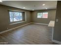 Brightly lit living room featuring hardwood flooring, ample windows, and connected breakfast bar seating at 3538 W Sierra Vista Dr, Phoenix, AZ 85019