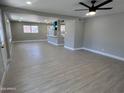 Bright open-concept living room featuring hardwood flooring connected to the kitchen with breakfast bar seating at 3538 W Sierra Vista Dr, Phoenix, AZ 85019