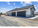 Three-car garage offering ample parking space, with white brick and sleek black doors at 3989 E Freeman Ln, San Tan Valley, AZ 85140