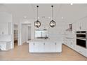 Modern kitchen with white cabinetry, stainless steel appliances, a large island, and stylish pendant lights at 3989 E Freeman Ln, San Tan Valley, AZ 85140