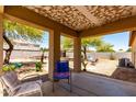Comfortable covered patio area with neutral colors, a ceiling fan, and a view of the yard at 40264 W Lococo St, Maricopa, AZ 85138