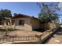 View of the exterior displaying a brick home, fence, and spacious yard at 4902 W Vista Ave, Glendale, AZ 85301