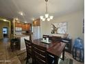 Inviting dining area with elegant chandelier, stylish artwork, and seamless flow to kitchen at 650 N Hawes Rd # 4007, Mesa, AZ 85207
