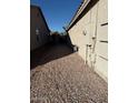 Exterior shot of a home's gravel side yard with a stucco wall at 7232 W Zak Rd, Phoenix, AZ 85043