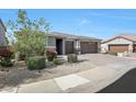 Inviting home with a manicured front yard, a brick driveway, and an attached three-car garage at 7512 W Warner St, Phoenix, AZ 85043