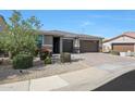 Attractive single-story home with desert landscaping, brick driveway, and an attached three-car garage at 7512 W Warner St, Phoenix, AZ 85043