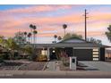 Charming single-story home with desert landscaping, palm trees, and a modern dark gray two-car garage at 8730 E Montecito Ave, Scottsdale, AZ 85251