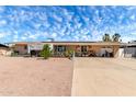 Single-story home featuring desert landscaping, a driveway, and blue skies with wispy clouds at 930 E Friar Ave, Apache Junction, AZ 85119