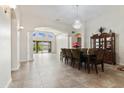 Open-concept dining room with elegant chandelier, tile floors, and plenty of natural light at 10040 E Grandview St, Mesa, AZ 85207