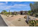 Modern home exterior featuring drought-tolerant landscaping, circular driveway, and a neutral color palette at 11123 E Monument Dr, Scottsdale, AZ 85262