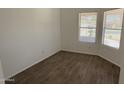 Bright bedroom with wood-look tile flooring and a window with blinds at 12505 W Adams St, Avondale, AZ 85323