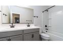 Modern bathroom features a double sink vanity, a combination tub and shower, and sleek black fixtures at 12547 W Stella Ln, Litchfield Park, AZ 85340