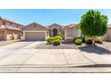 Charming single-story home with a well-manicured front yard, mature trees, and a spacious three-car garage at 13561 W Montebello Ave, Litchfield Park, AZ 85340