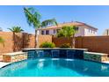 Beautiful pool area with a soothing waterfall feature and vibrant landscaping; ideal for outdoor enjoyment at 13561 W Montebello Ave, Litchfield Park, AZ 85340